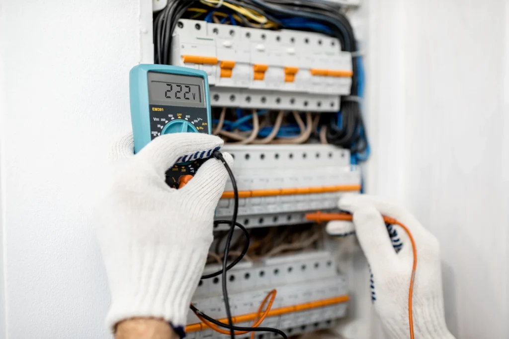 Behörig elektriker utför byte av elcentral i ett gammalt hus i Malmö, där hanteringen av äldre kablar är en del av installationskostnaden.